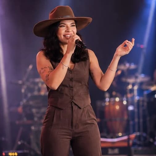 Layra Mota cantando com microfone no palco